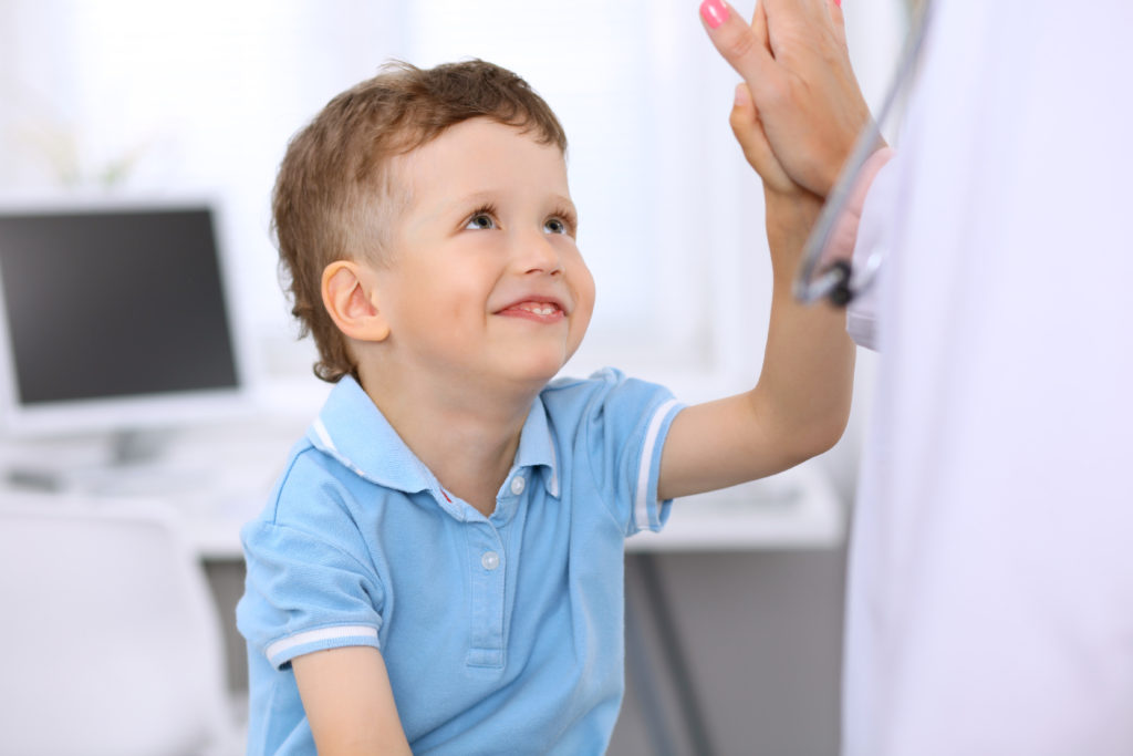 Happy boy giving doctor a high five 